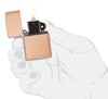 Zippo aansteker basismodel in geborsteld massief koper en zwart inzetstuk geopend met vlam in gestileerde hand