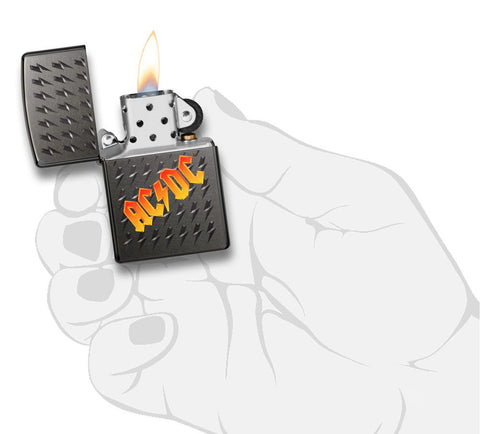 Vooraanzicht Black Ice Zippo-aansteker met AC/DC-logo en kleine gegraveerde bliksemschichten open met vlam in handpalm