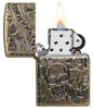 Zippo-aansteker antiek messing met diep gegraveerde doodshoofden open met vlam